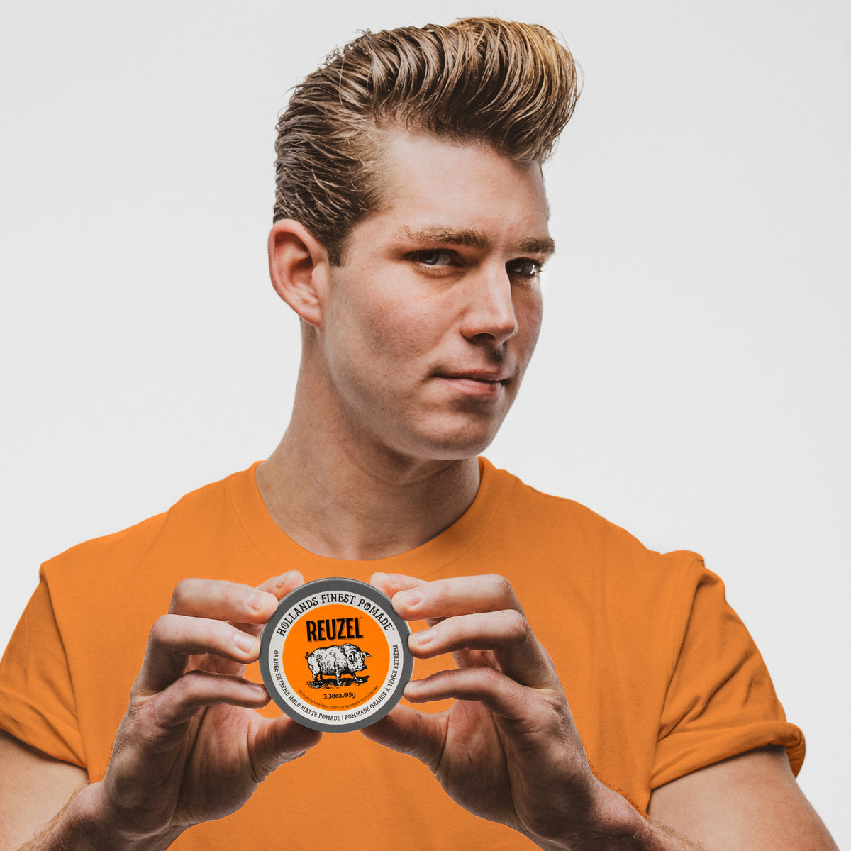 Reuzel Orange Extreme Hold Matte Pomade jar with orange label and black lid, showcasing the product's packaging.