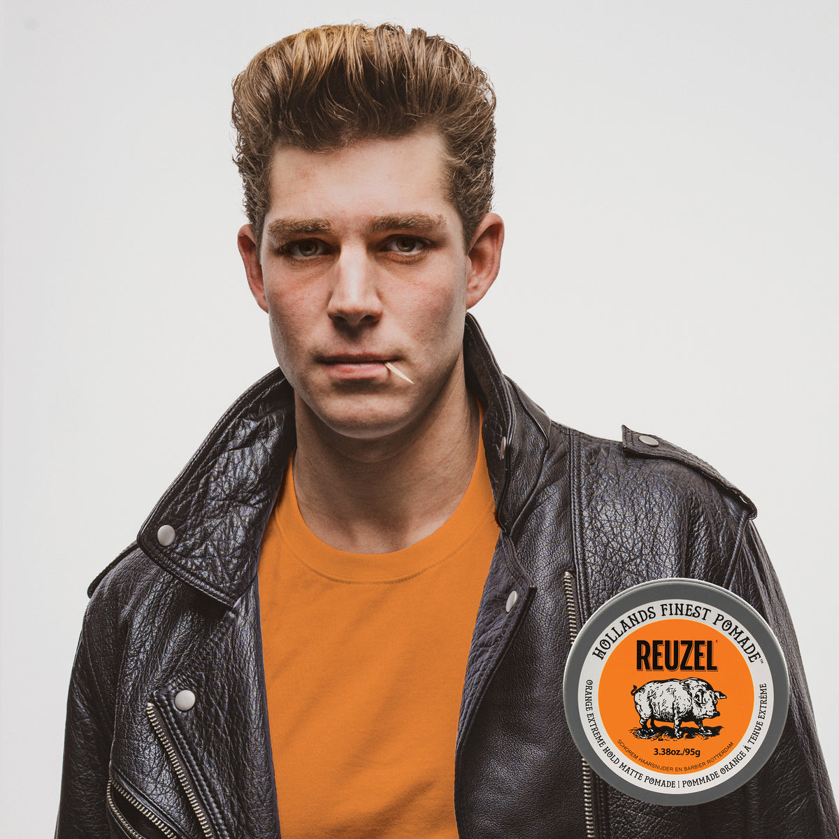 Reuzel Orange Extreme Hold Matte Pomade jar with orange label and black lid, showcasing the product for strong, matte hairstyle hold.