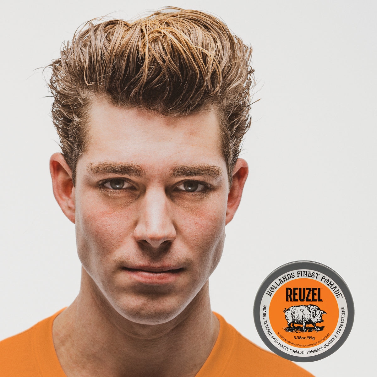 Reuzel Orange Extreme Hold Matte Pomade jar with orange label and black lid, showcasing the product's branding and packaging.