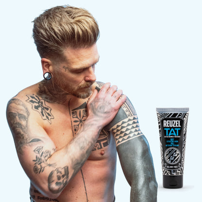 Reuzel TAT Buff Exfoliating Wash for tattoo aftercare, showing a clear bottle of exfoliating cleanser for skin renewal.