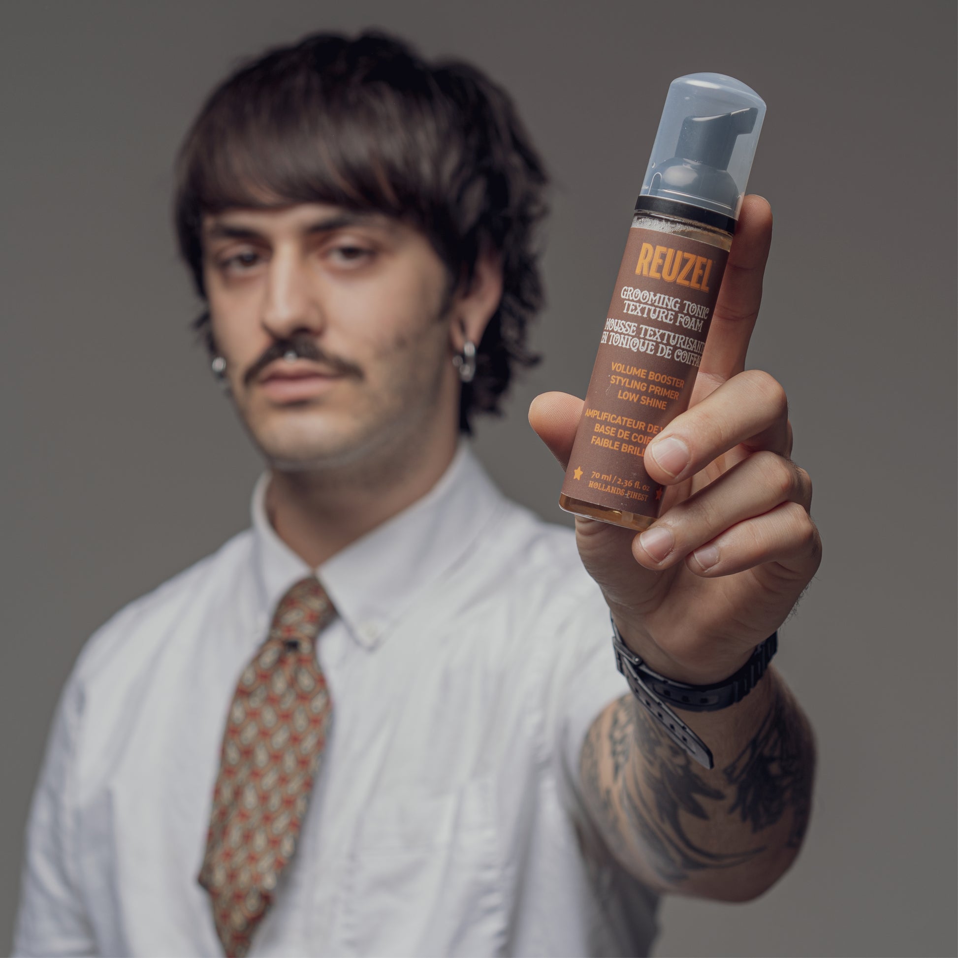 Reuzel Grooming Tonic Texture Foam for hair styling, showing the foam applied to hair with a sleek, textured finish.