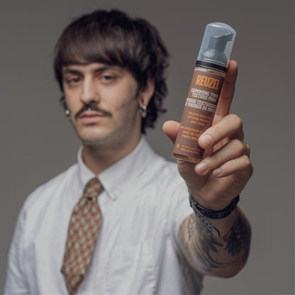 Reuzel Grooming Tonic Texture Foam for hair styling, showing the foam applied to hair with a sleek, textured finish.