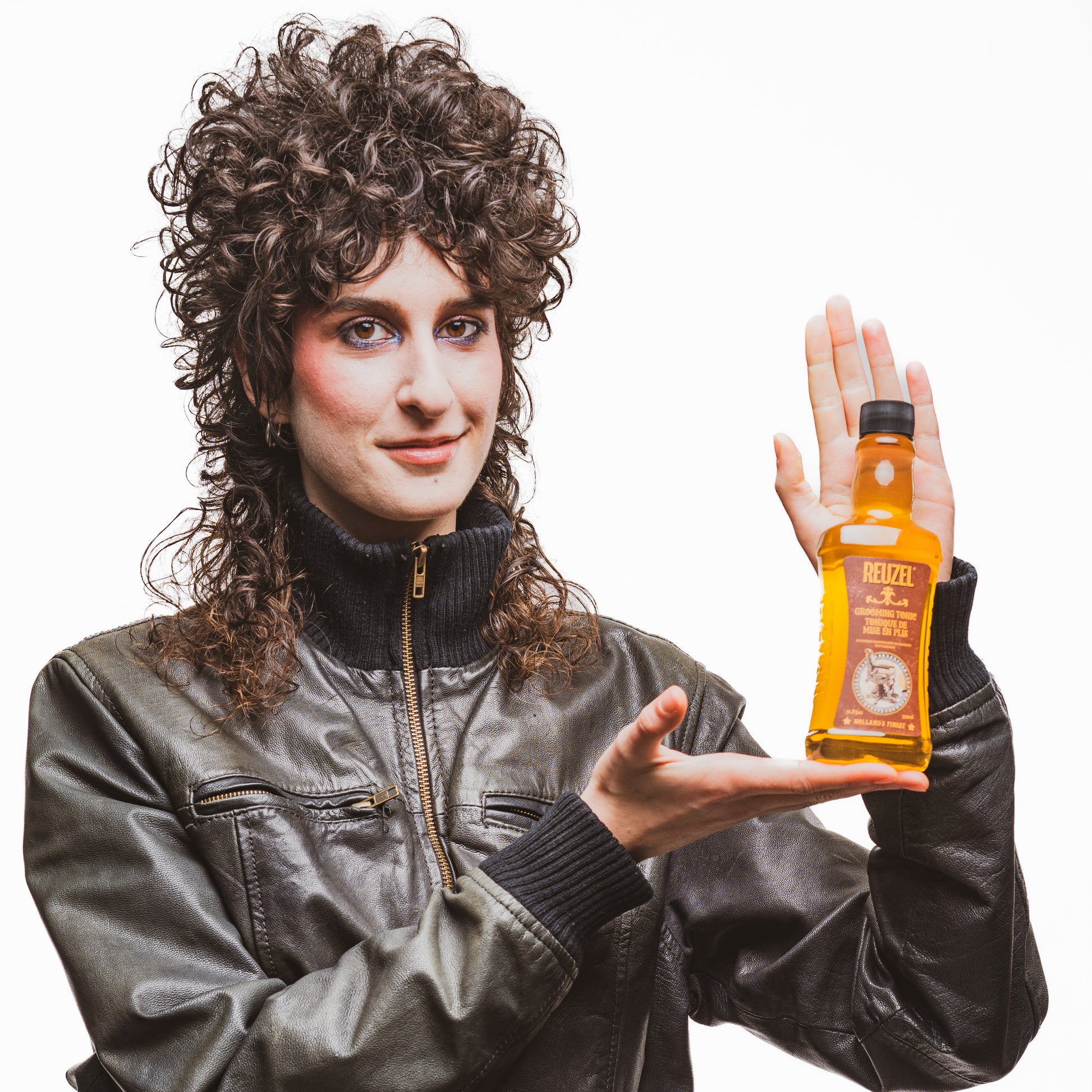 Reuzel grooming tonic in a clear bottle, showing hair tonic liquid with a modern label, used for styling and hair care.