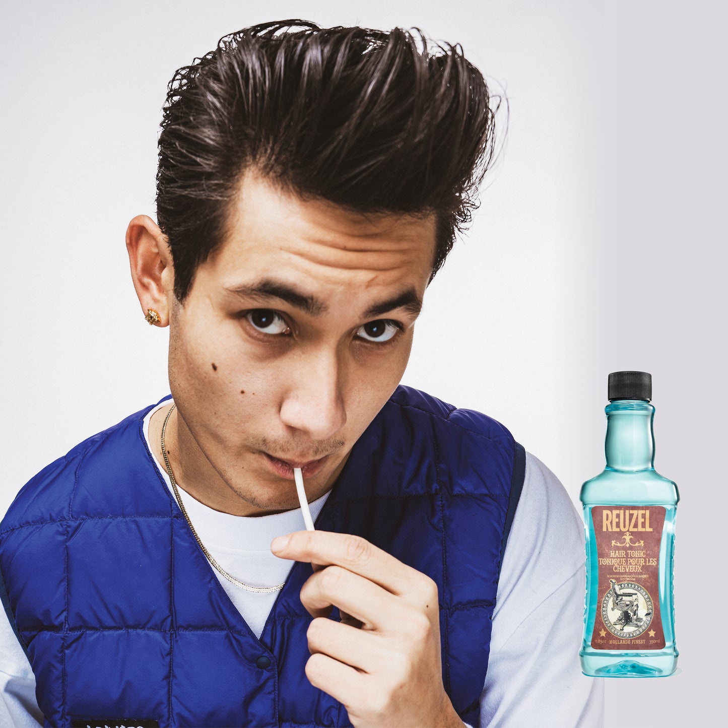 Reuzel Hair Tonic bottle with label, showcasing the hair care product on a plain background.