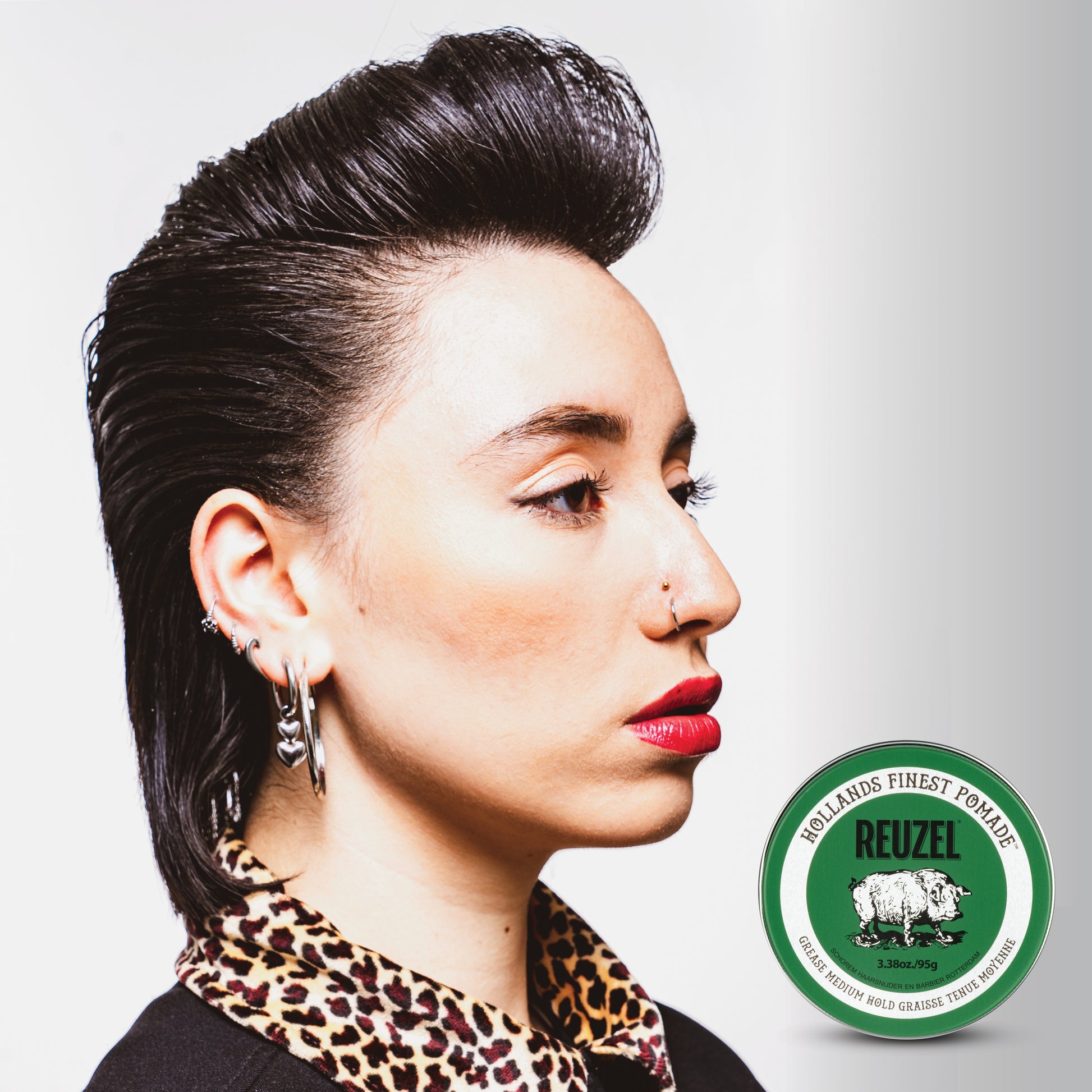 Green Reuzel Pomade Grease jar with label, showcasing the classic styling product for shiny, textured hair hold.