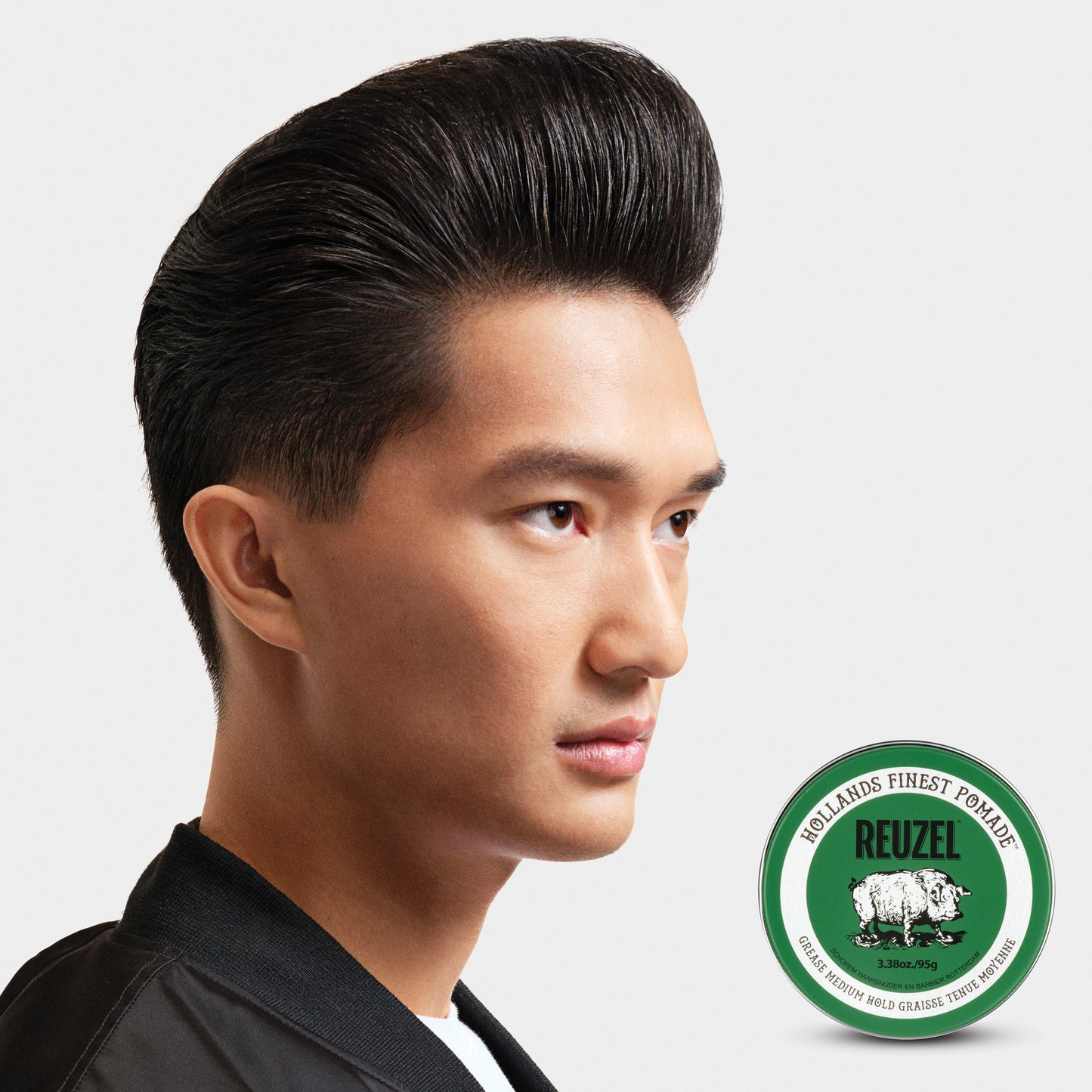 Reuzel Green Pomade grease jar with a green label, showcasing a thick, glossy pomade product for styling hair.
