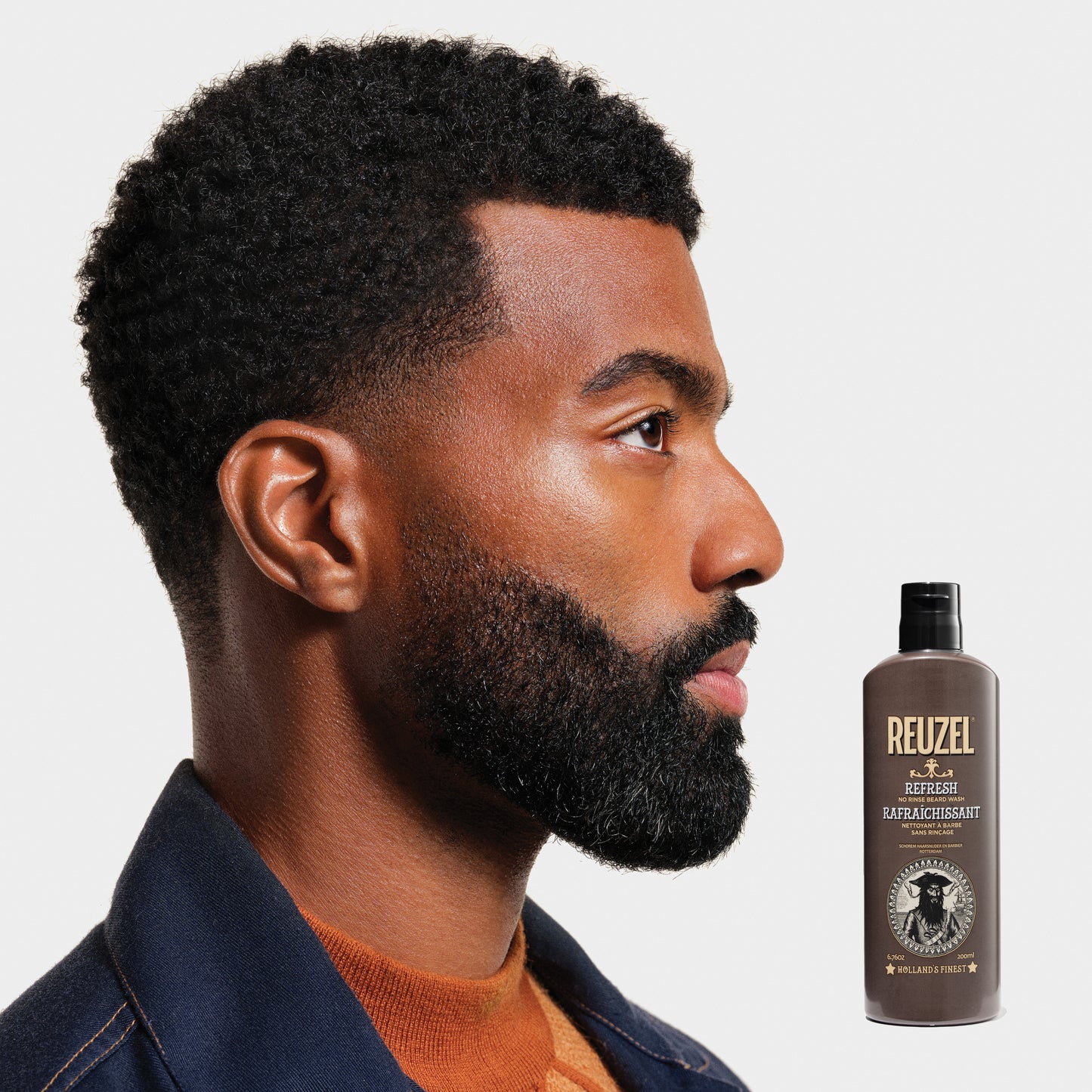 Reuzel Refresh No Rinse Beard Wash in a bottle, designed for cleaning and refreshing men's beard grooming products.