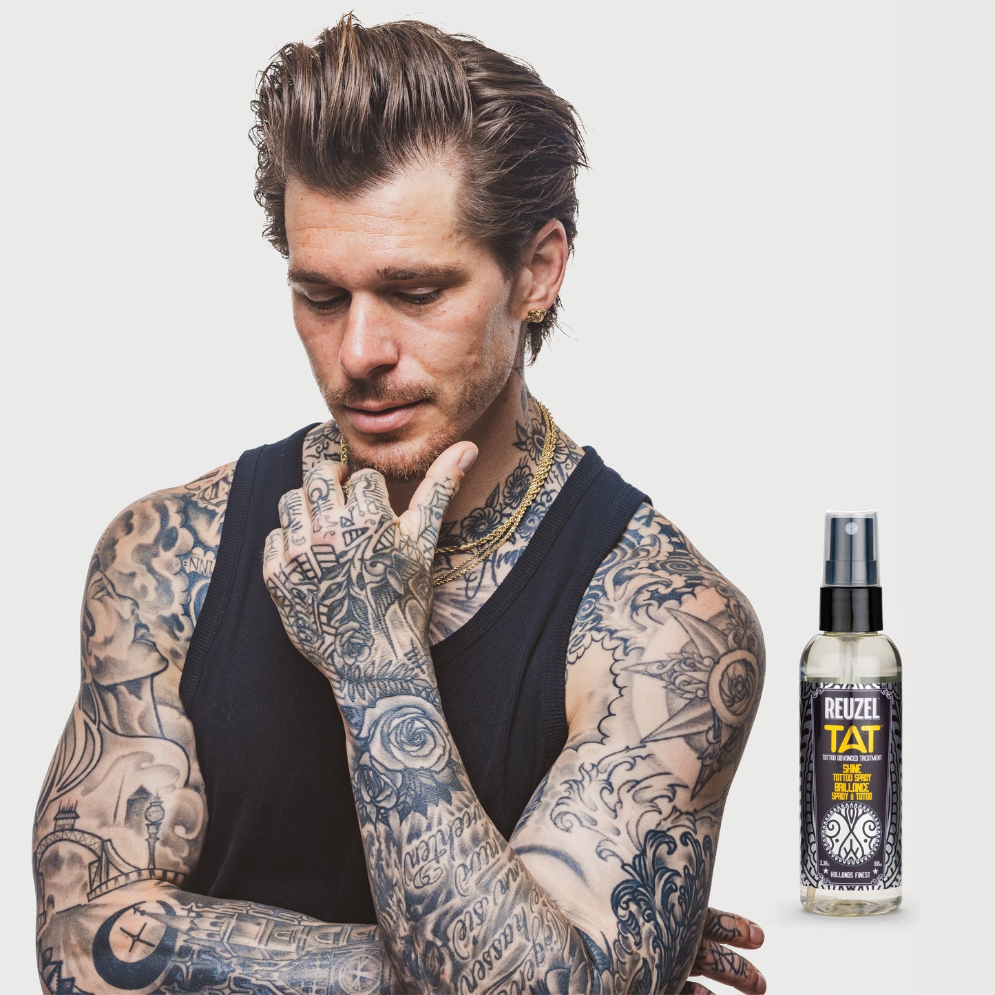 Reuzel TAT Shine Tattoo Spray used for tattoo aftercare, featuring a spray bottle with the product label visible.