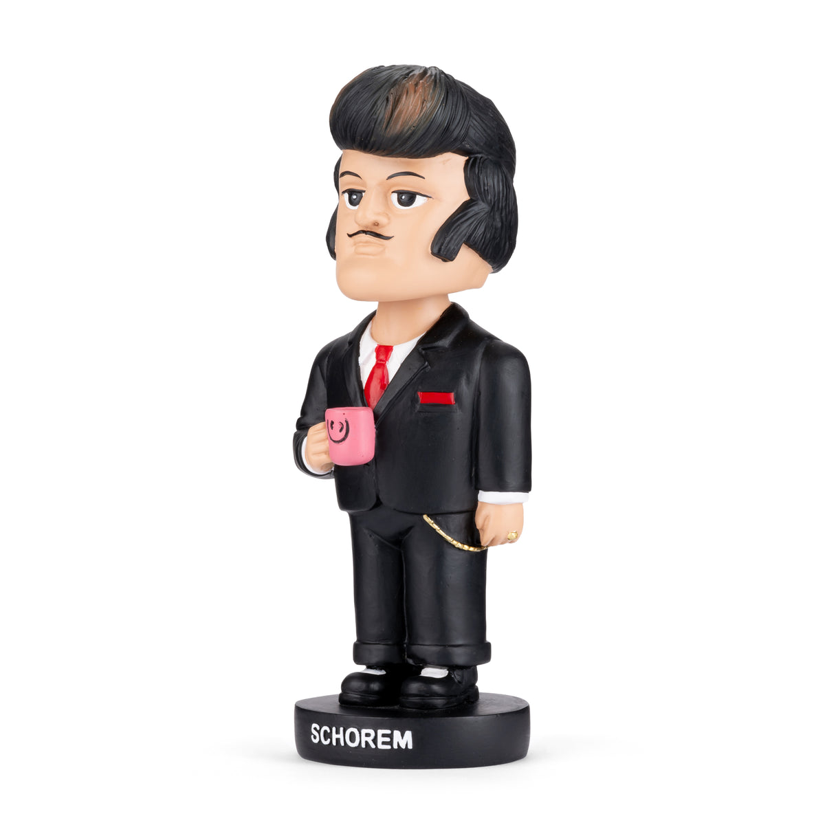 A stylized bobblehead figurine of a man with dark hair and a mustache, wearing a black suit, white shirt, and red tie, holding a pink mug. The base is labeled 'SCHOREM' and is photographed on a clean white background.