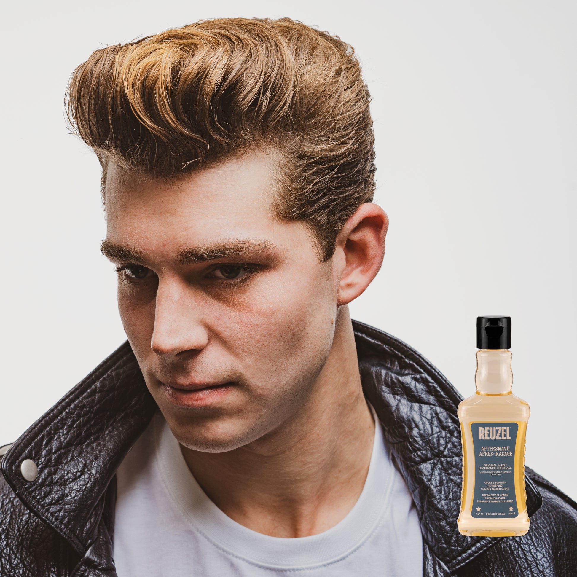 Reuzel aftershave perfume and cologne bottle with a sleek design, showcasing the Reuzel branding and a modern aesthetic.