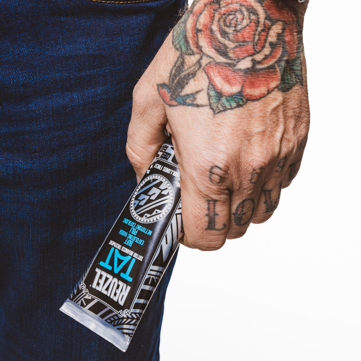 Reuzel TAT Buff Exfoliating Wash for tattoo aftercare, showing the product bottle with label and cleansing ingredients.