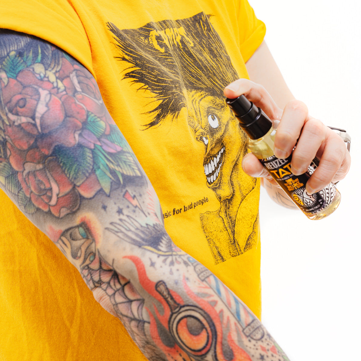 Reuzel TAT Shine Tattoo Spray for aftercare, featuring a sleek spray bottle with vibrant branding and clear product labeling.
